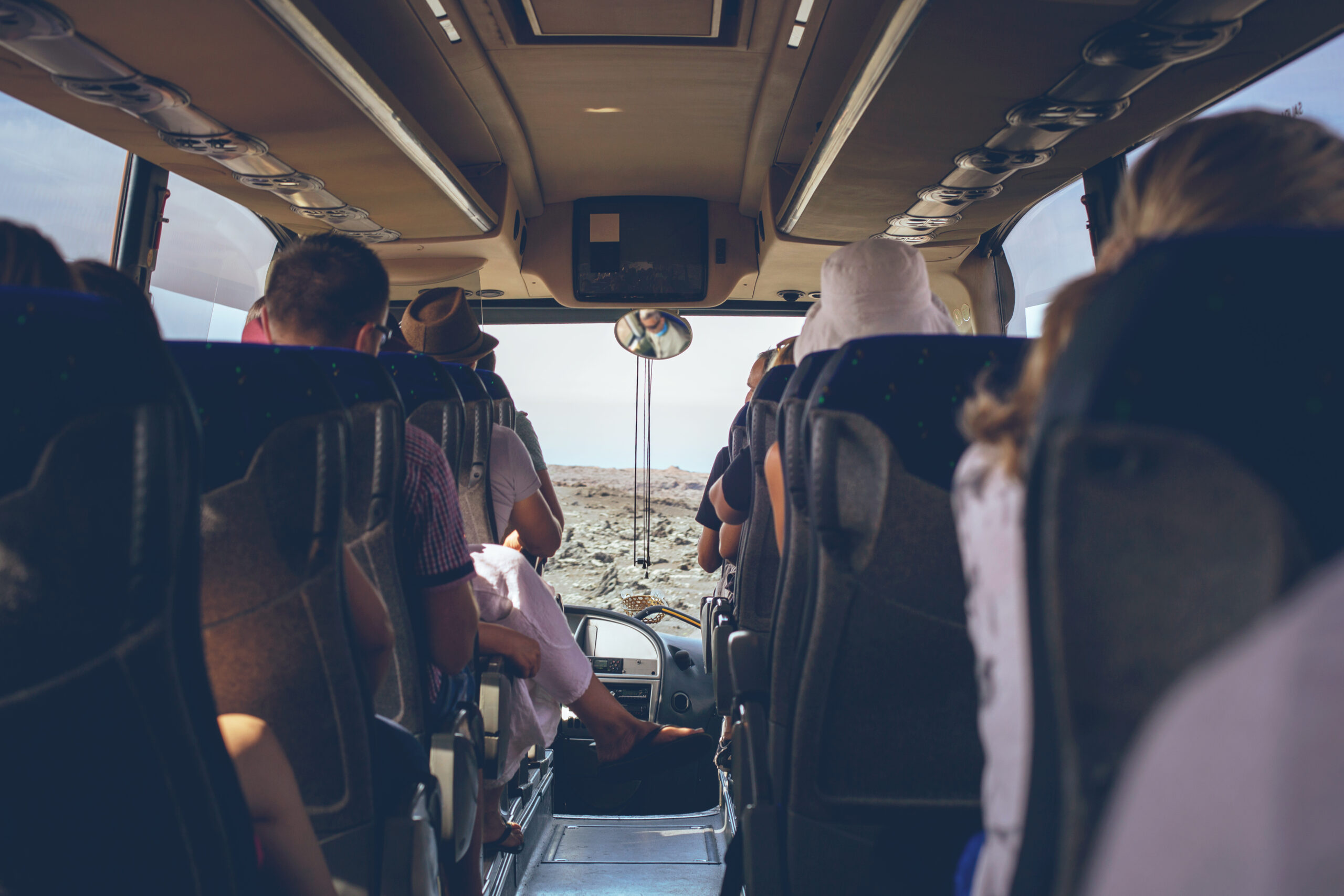 tourist bus interior with people sitting back view scaled